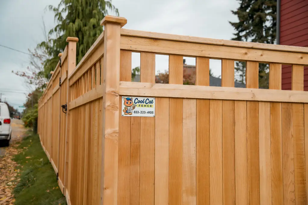 A high-quality cedar wooden fence featuring a horizontal lattice top and vertical privacy boards.