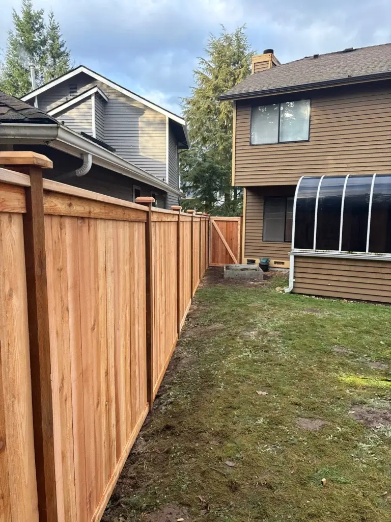 A long wooden privacy barrier along a grassy yard for a cedar fence installation Renton WA.